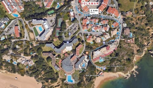 Vista aérea do Albufeira Inn em Praia dos Aveiros, com apartamentos e piscinas à beira-mar perto de Albufeira, Portugal