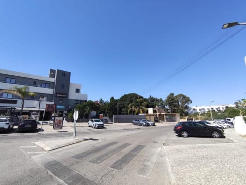 Edifício de apartamentos Albufeira Inn com estacionamento e vista da rua em Praia dos Aveiros, Portugal