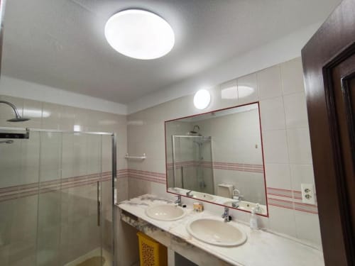 Casa de banho moderna com dupla lavatória, espelho grande e poliban no apartamento à beira-mar do Albufeira Inn