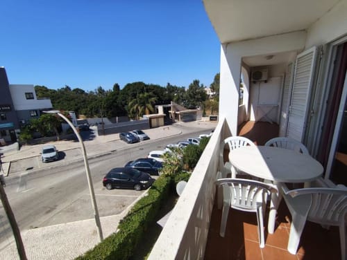 Terraço com móveis brancos com vista para o parque de estacionamento e árvores em Albufeira, Portugal