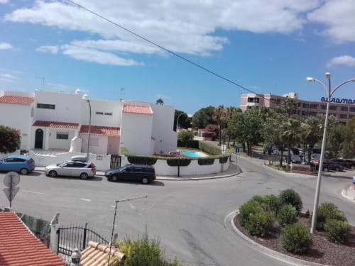 Edifício de apartamentos Albufeira Inn em Praia dos Aveiros, Portugal, com fachada branca, telhado de telhas vermelhas e área de piscina