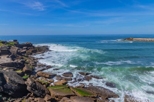 Costa rochosa com ondas turquesas na Albufeira Inn, Portugal, com vista para o Oceano Atlântico sob céu azul