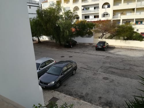 Estacionamento do Albufeira Inn com carros estacionados e prédio de apartamentos em Albufeira, Portugal