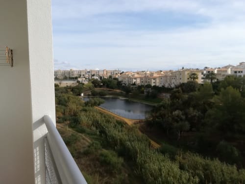 Vista da varanda do Albufeira Inn com vista para o rio, palmeiras e edifícios residenciais em Albufeira, Portugal