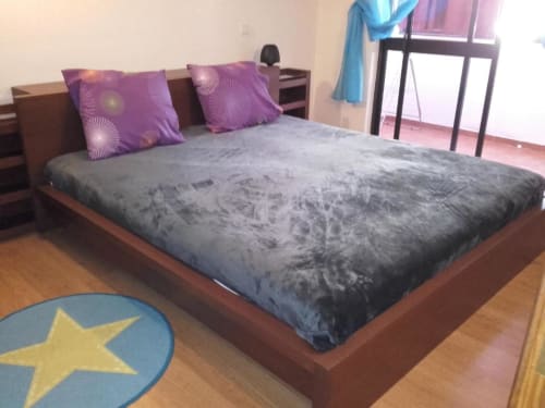 Quarto espaçoso no Albufeira Inn com cama queen, almofadas com padrão roxo, roupa de cama cinzenta e móveis de madeira