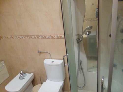 Casa de banho moderna no apartamento Albufeira Inn com sanita, bidé e poliban com box de vidro