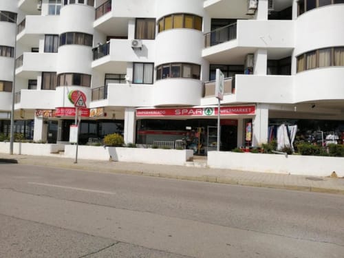Edifício do Albufeira Inn com loja SPAR e varandas brancas curvas em Albufeira, Portugal