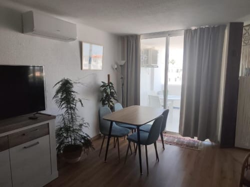 Apartamento moderno na Albufeira Inn com mesa de jantar, cozinha, TV, acesso à varanda e vista para a cidade