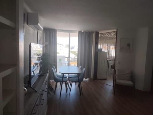 Sala moderna do Albufeira Inn com mesa de jantar, TV, acesso à varanda e vista para o mar em Albufeira, Portugal