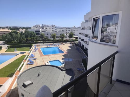 Vista da varanda do Albufeira Inn com piscinas e edifícios brancos de apartamentos em Portugal