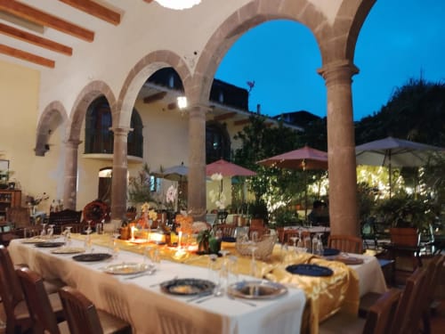 Elegante patio de comedor al aire libre en Casa Aroma de Café en Coatepec con columnas arqueadas y ambiente crepuscular