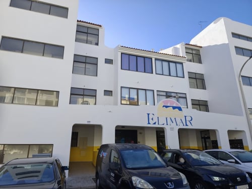 Edifício Albufeira Inn Elimar 3 com fachada branca, sinalética azul e carros estacionados em frente, Albufeira Portugal