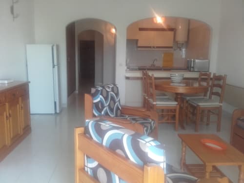 Espaço de estar do apartamento Albufeira Inn com móveis em madeira, cozinha e eletrodomésticos modernos