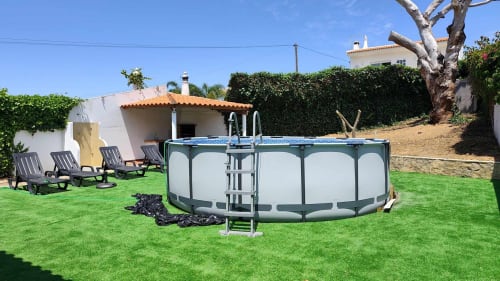 Villa com jardim, piscina redonda, espreguiçadeiras e casa de estilo mediterrânico em Olhos de Água, Portugal