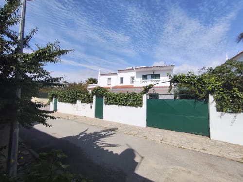 Villa branca com portão verde e paredes cobertas de hera em Olhos de Água, Portugal na Albufeira Inn