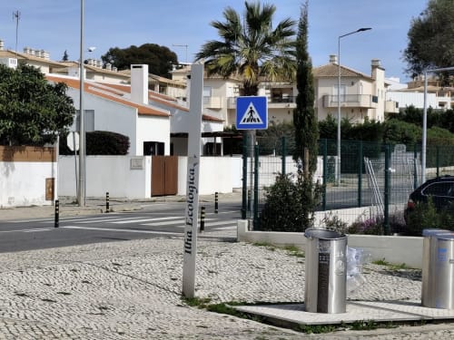 Passagem de peões em Olhos de Água, Albufeira com vivendas brancas e palmeiras na zona residencial