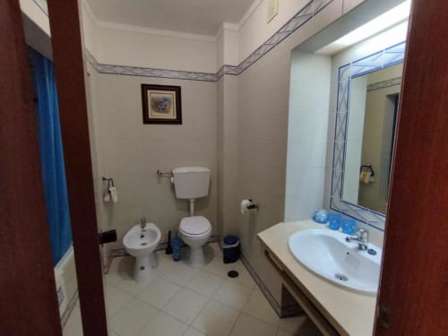 Casa de banho moderna com sanita, bidé e duas pias no estúdio do Albufeira Inn, Portugal