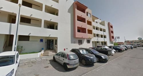 Edifício do Albufeira Inn com carros estacionados e entrada, mostrando arquitetura moderna em Albufeira, Portugal