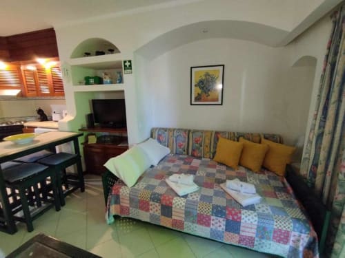 Estúdio no Albufeira Inn com cama, kitchenette, área de refeições e nichos arqueados verdes com prateleiras embutidas