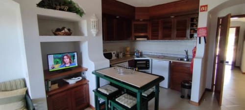 Cozinha e sala de jantar no apartamento do Bellavista Tenis Clube em Albufeira Inn, com mesa de jantar verde, marcenaria em madeira e