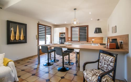 Cocina y comedor moderno en la villa de Millau con mostradores de madera, barra y piso con azulejos decorativos