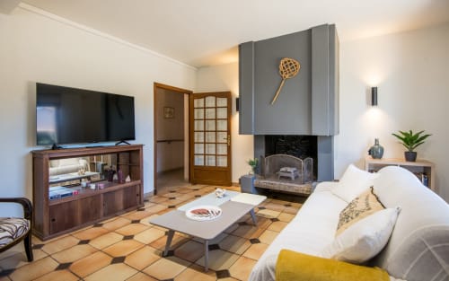 Salón de villa moderna con chimenea, televisor pantalla plana y muebles contemporáneos en Millau