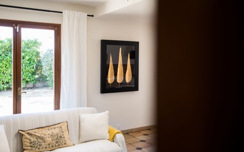Sala de estar moderna en la villa de Millau con sofá a rayas, obra de arte decorativa dorada y vista al jardín a través de puertas francesas