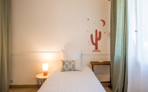 Dormitorio acogedor en la villa La Conciergerie, Millau, con arte temático de cactus y iluminación cálida