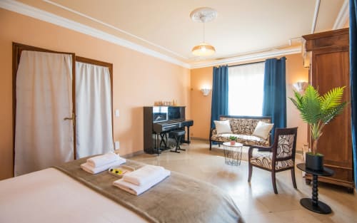 Amplio dormitorio de villa en Millau con piano, zona de estar y vistas al jardín en La Conciergerie