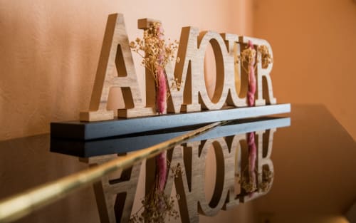 Letrero de madera "AMOR" con flores secas en una estantería en La Conciergerie, villa en Millau, Francia