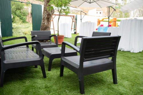 Modernas sillas lounge negras sobre el césped del espacio de eventos al aire libre de Alojamientos Las Mellis en Antequera