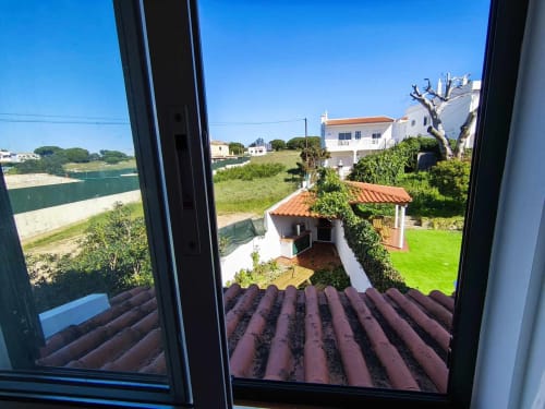 Vista da Pousada Albufeira com telhas de barro, jardim impecável, villa branca e paisagem costeira em Portugal