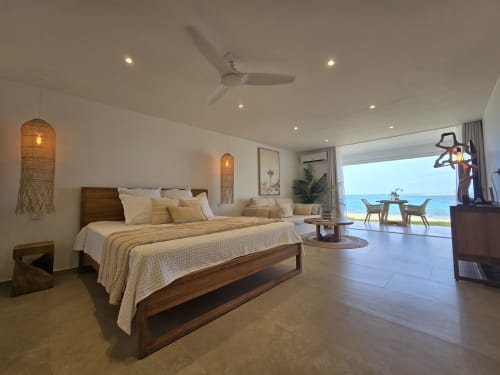 Chambre de luxe face à la mer à Grimaud Locations avec vue océan, lit en bois, ventilateur de plafond et balcon vue mer à Cul-de-Sac