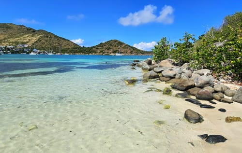 Lagon turquoise de Cul-de-Sac avec plage de sable blanc, rochers et voiliers ancrés dans les eaux cristallines des Caraïbes