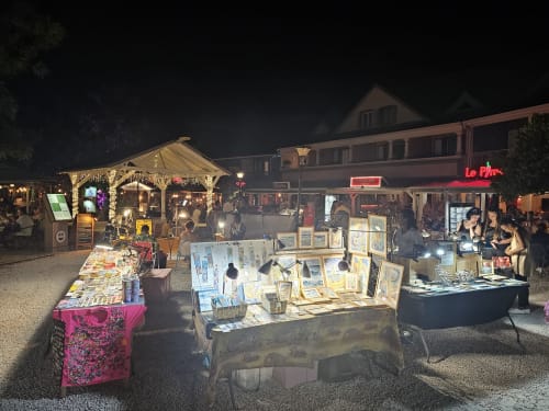 Marché d'art nocturne à Cul-de-Sac avec étals illuminés et expositions d'œuvres locales