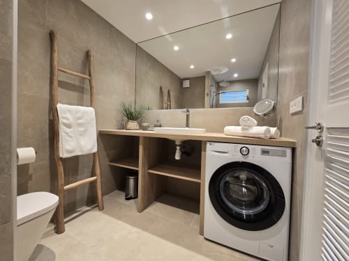 Salle de bain moderne à l'appartement Paradise Lagoon à Grimaud, avec lave-linge, double vasque et boiseries