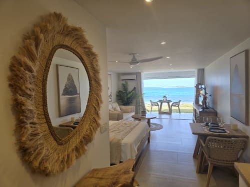 Appartement de luxe en bord de mer à Grimaud Locations avec vue océan, miroir cadre cordage et mobilier design.
