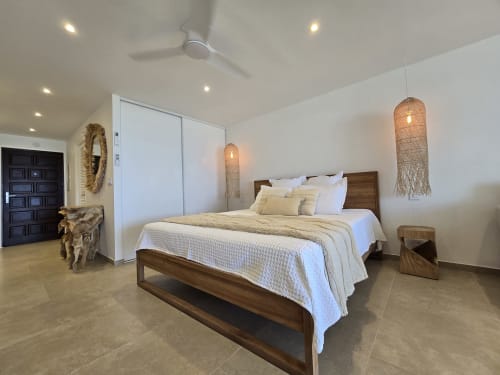 Chambre moderne à Grimaud Locations Paradise Lagoon à Cul-de-Sac avec lit en bois, suspensions tressées et armoire blanche