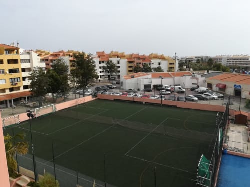 Complexo desportivo Bellavista Ténis Clube com campos de futebol de relva sintética verde, complexo residencial Albufeira com telhados vermelhos