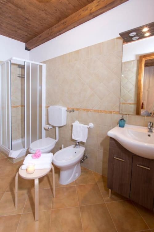 Modern bathroom with shower, toilet, bidet, and sink in Casa di Cinti studio apartment, Loiano