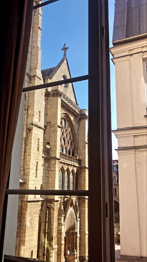 View from Cocoon Gallery Paris studio window of Gothic church with cross and ornate stonework in Paris cityscape