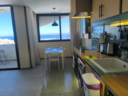 Modern kitchen and dining area in SAMYAflat Tangier apartment with sea view balcony and contemporary furnishings