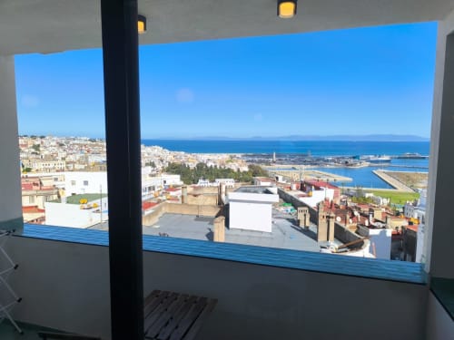 Panoramic balcony view of Tangier coastline with Mediterranean Sea, white-washed buildings, and port from SAMYAflat apartment