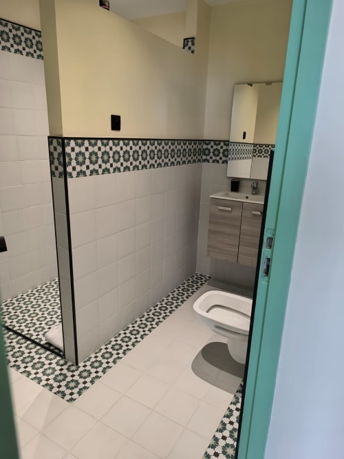 Modern bathroom at SAMYAflat in Tangier with walk-in shower, geometric tile accents, and vanity sink
