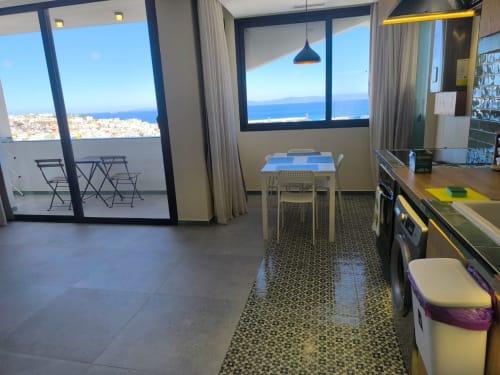 Modern apartment in Tangier with panoramic sea views, dining area, and balcony overlooking coastal cityscape