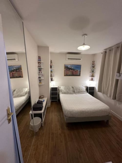Chambre moderne à la Villa des Palmiers avec lit queen, miroir, étagères et parquet à Villeneuve-sur-Lot