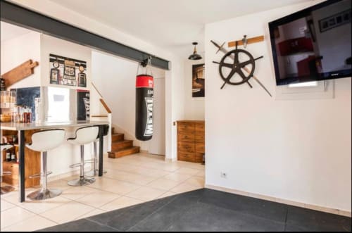 Salle de sport moderne à la Villa des Palmiers B&B avec sac de boxe, décoration style nautique et bar