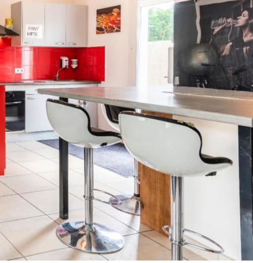 Cuisine moderne avec dosseret rouge, placards blancs et coin bar à Villa des Palmiers B&B à Villeneuve-sur-Lot