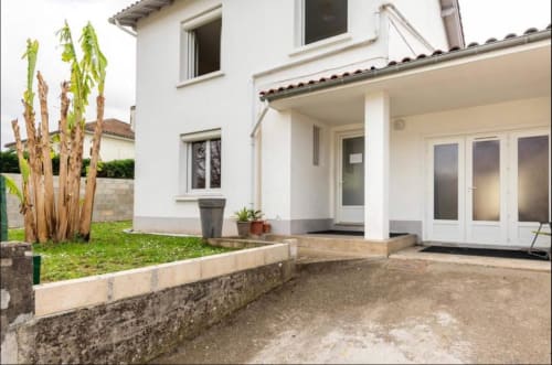 Terrasse élégante de la Villa des Palmiers à Villeneuve-sur-Lot avec portes-fenêtres, jardin et palmiers