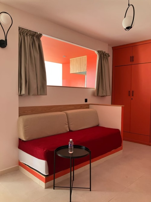 Modern living room with red sofa, beige pillows, and sea-view window in YaYaCaSa Ocre apartment at SAMYAflat Tangier hotel